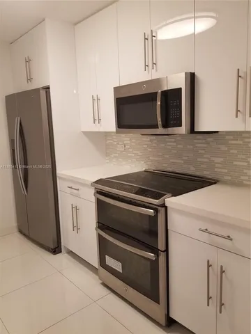 a kitchen with stainless steel appliances and white cabinets