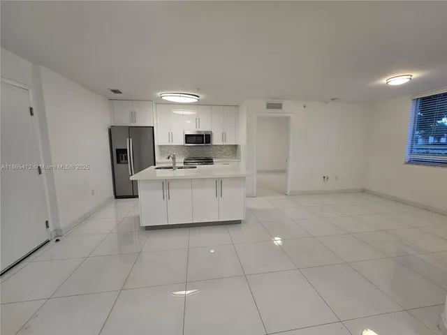 a kitchen with stainless steel appliances a refrigerator sink and cabinets