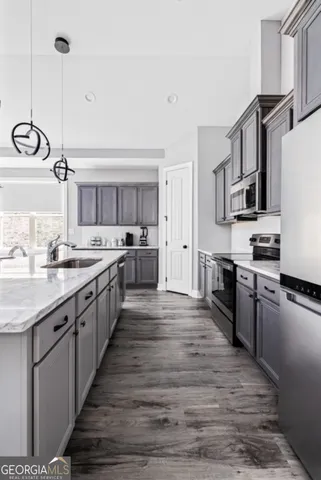 a large kitchen with stainless steel appliances lots of counter space and wooden floor