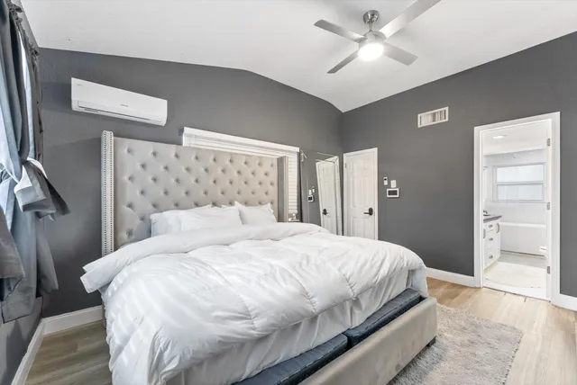 a bedroom with a large bed and a chandelier