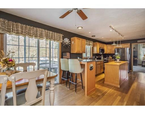 95 Haggerty Road Charlton, MA 01507 - Photo 8 of 30 a kitchen with stainless steel appliances kitchen island granite countertop a table chairs and a view of living room