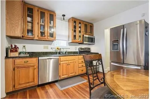 a kitchen with stainless steel appliances granite countertop a refrigerator and wooden cabinets