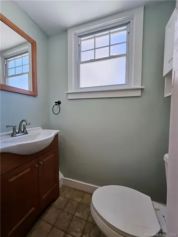 a bathroom with a toilet a sink and a window