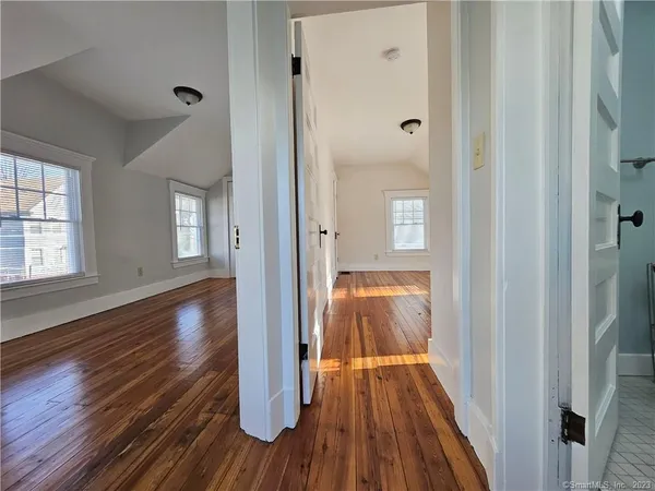 a view of a hallway with wooden floor and closet area