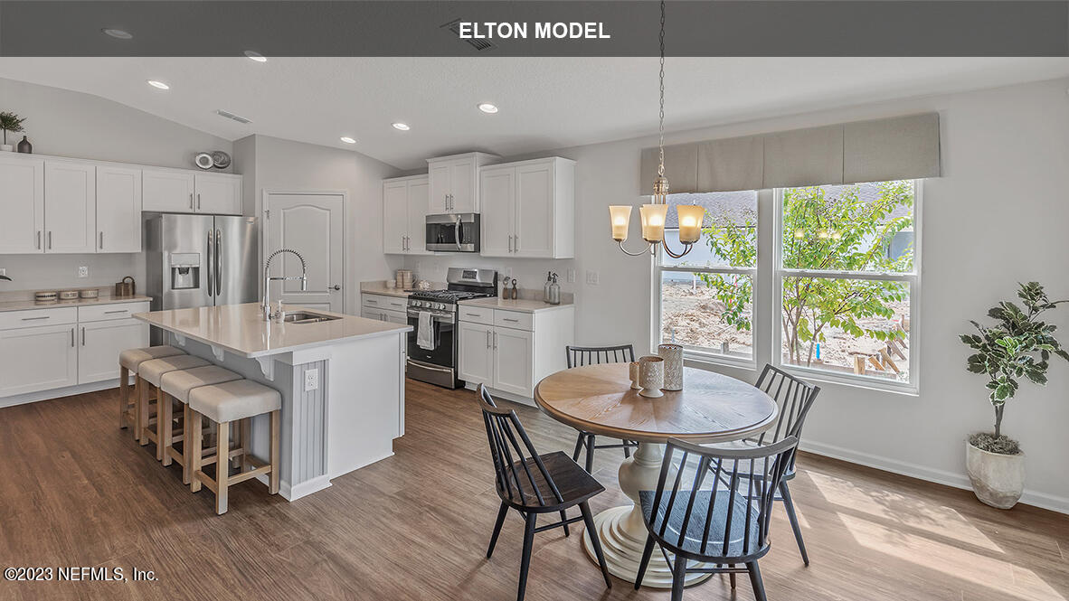 65 Zancara Street St. Augustine, FL 32084 - Photo 7 of 45 a kitchen with kitchen island a dining table and chairs