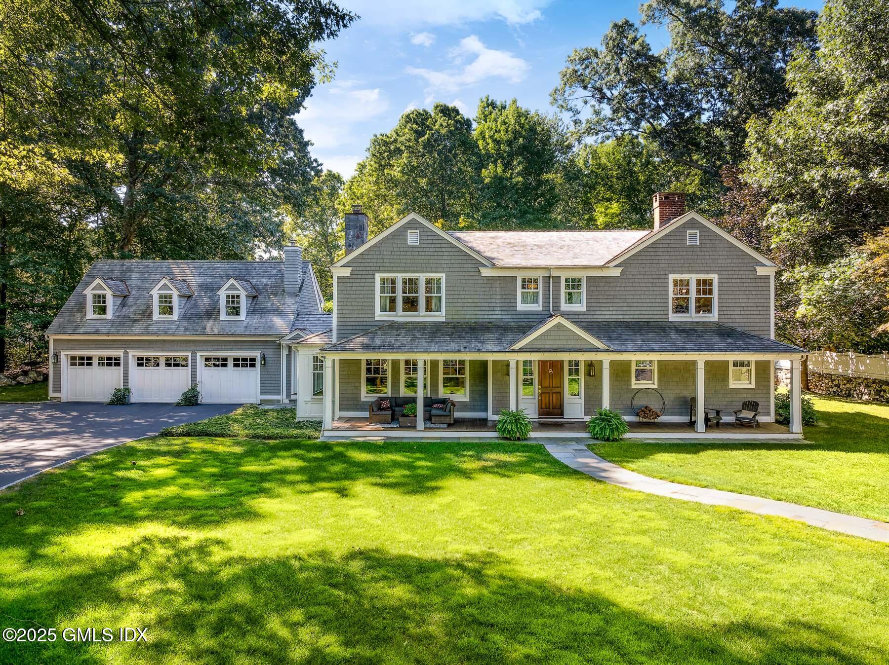 107 Cognewaugh Road Cos Cob, CT 06807 - Photo 1 of 32 a front view of a house with a yard table and chairs