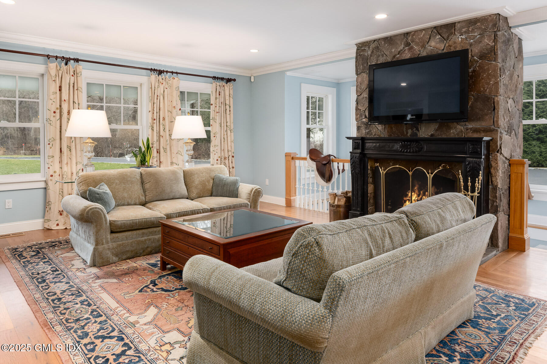 107 Cognewaugh Road Cos Cob, CT 06807 - Photo 3 of 32 a living room with furniture a flat screen tv and a fireplace
