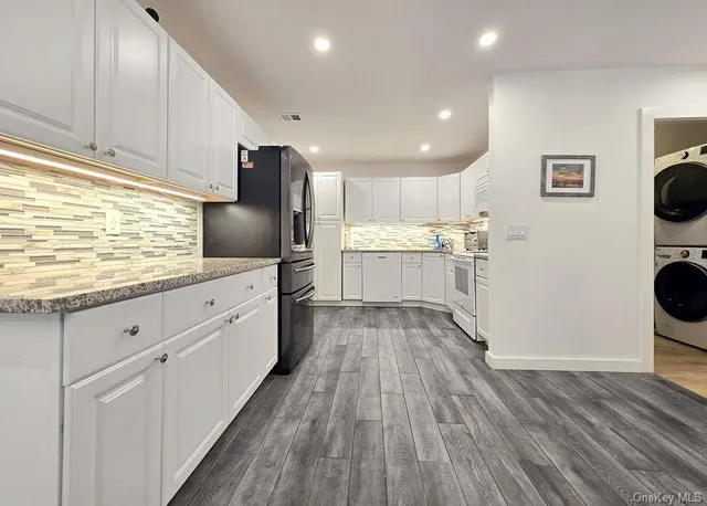 a kitchen with stainless steel appliances granite countertop wooden floors and white cabinets