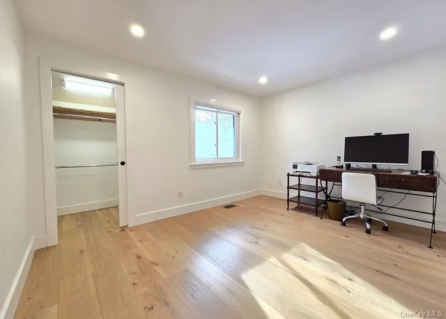 a view of work space with wooden floor and windows
