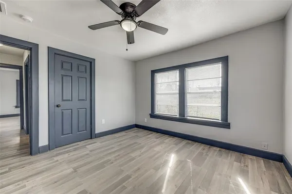a view of an empty room with a window and wooden floor
