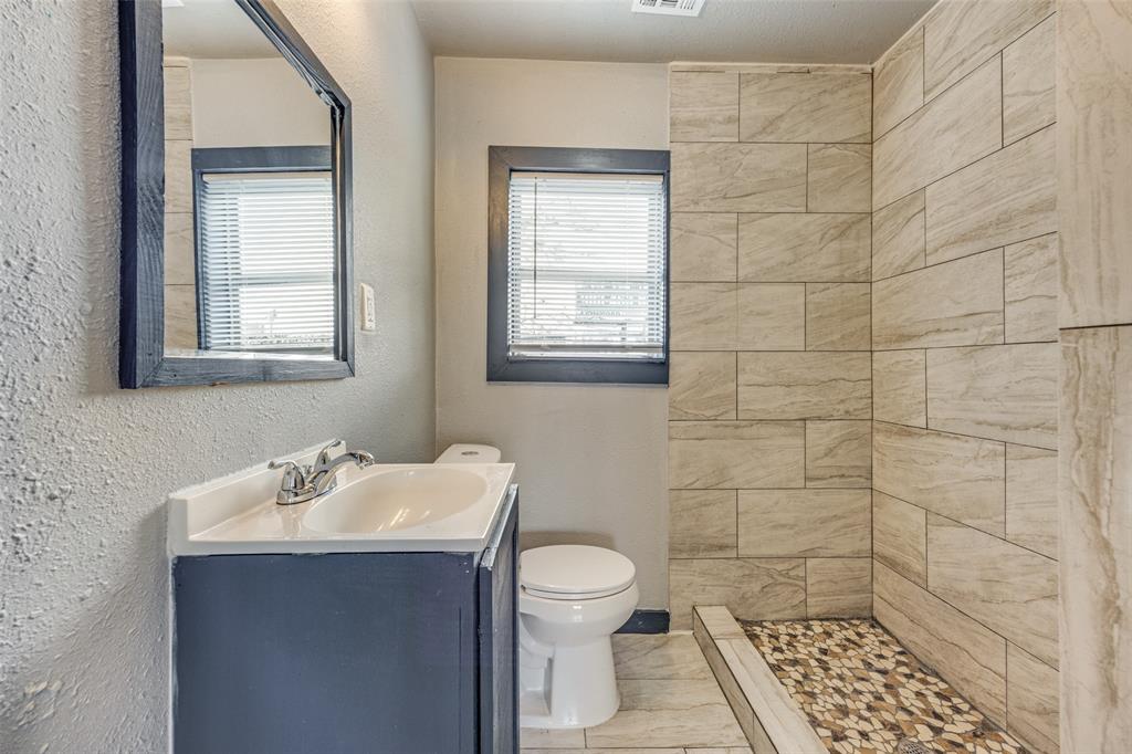 522 North Austin Avenue Denison, TX 75021 - Photo 20 of 25 a bathroom with a sink a toilet and a mirror