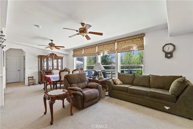 a living room with furniture a ceiling fan and a window
