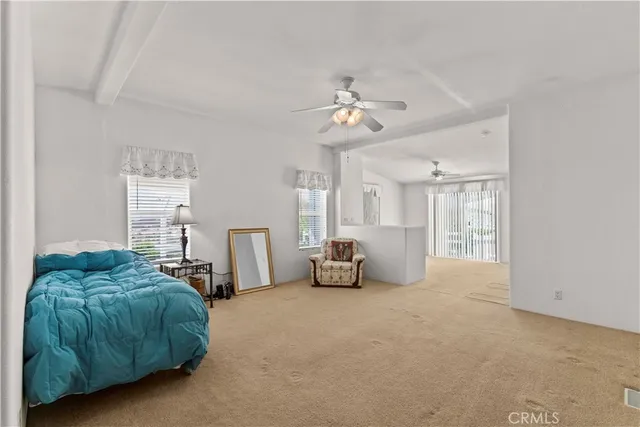 a spacious bedroom with a bed and a chandelier