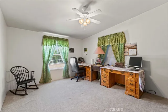 a view of a workspace with furniture and a window