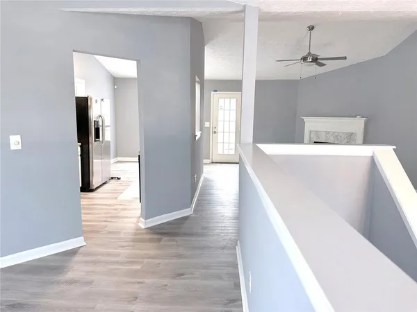 a view of a hallway with wooden floor and a living room