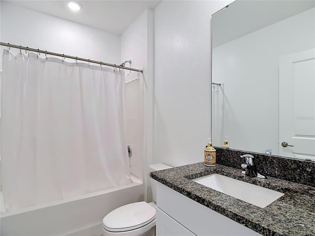 1633 Red Loop Lakeland, FL 33801 - Photo 18 of 60 a bathroom with a granite countertop sink toilet and shower