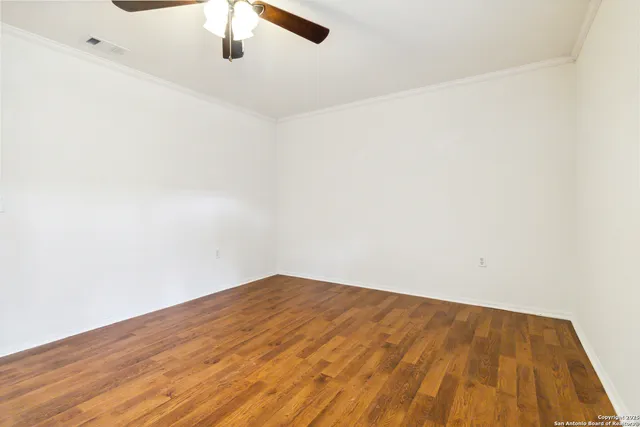 a view of empty room with wooden floor