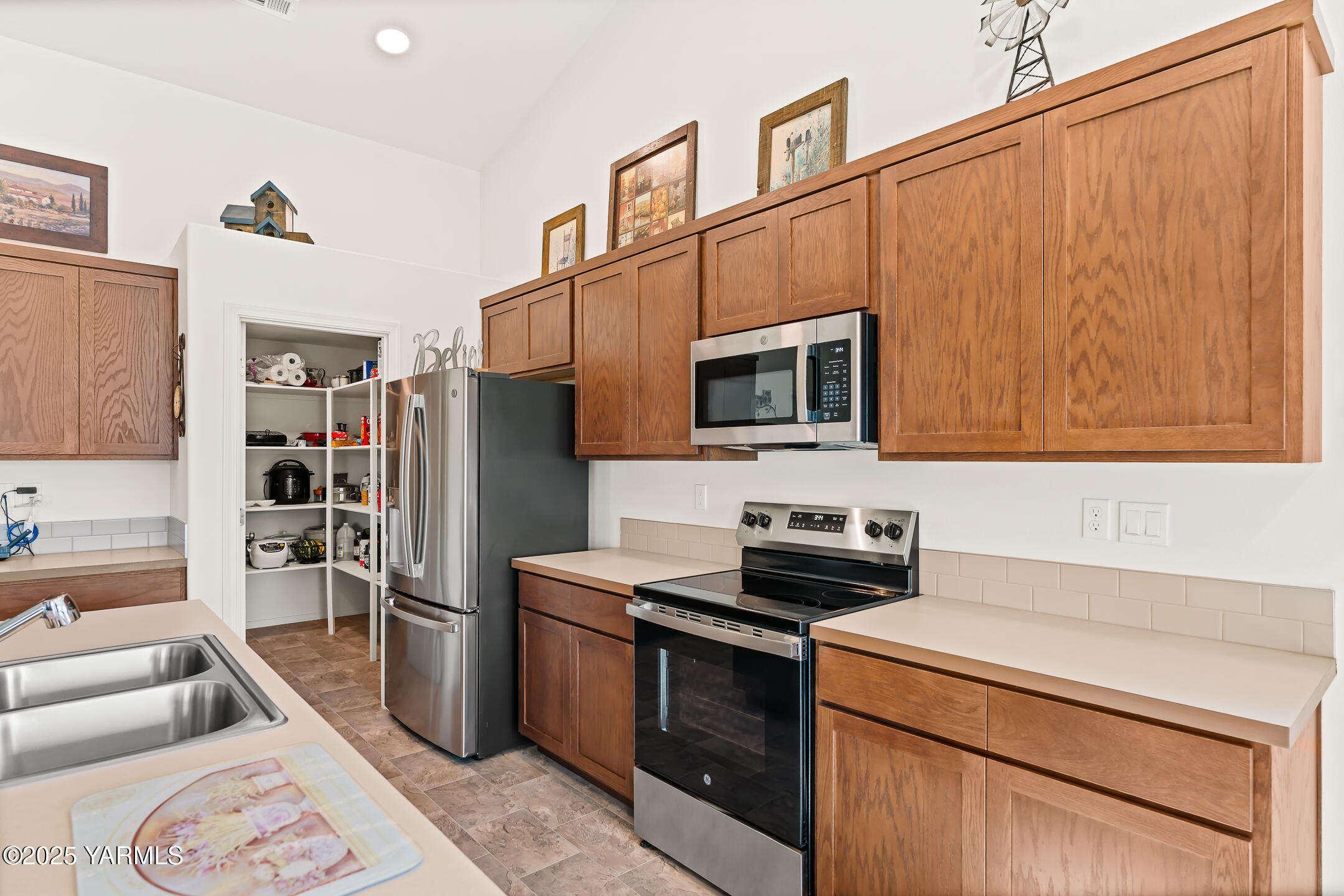 12312 Nelson Road Yakima, WA 98903 - Photo 11 of 36 a kitchen with stainless steel appliances a stove a microwave and a refrigerator