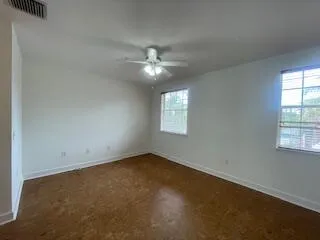 an empty room with a window and a fan
