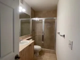 a bathroom with a granite countertop sink toilet and shower