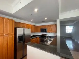 a kitchen with stainless steel appliances granite countertop a refrigerator a sink a stove and island