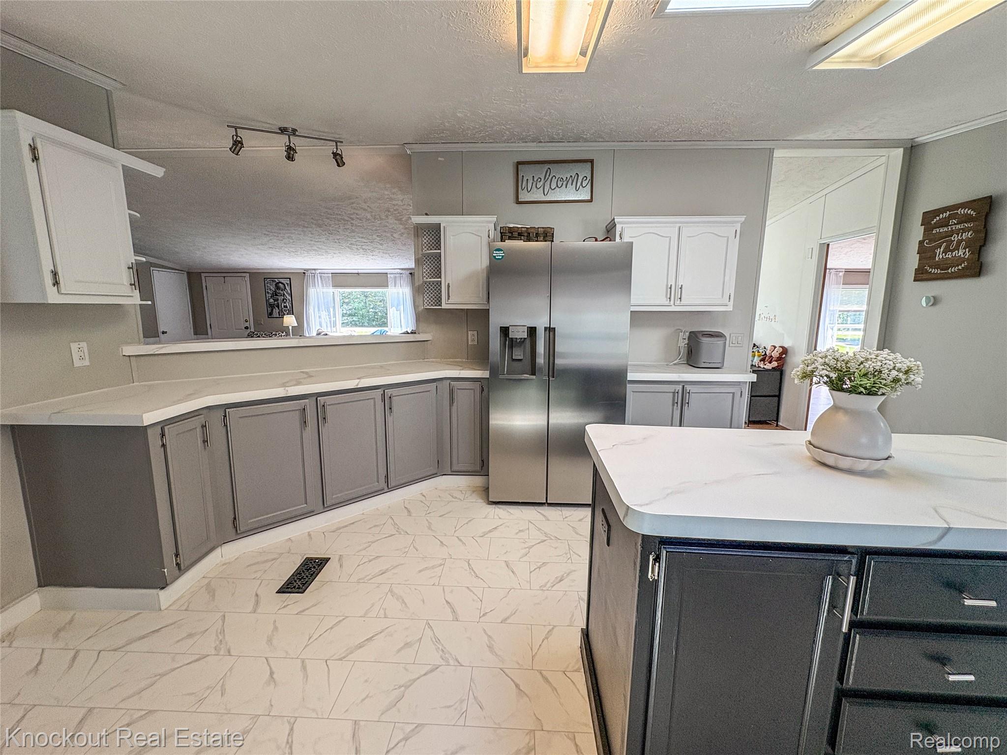 7760 Bell Road Birch Run, MI 48415 - Photo 16 of 68 Modern kitchen featuring white-finish countertops, stainless steel refrigerator, white and grey cabinetry, and track lighting