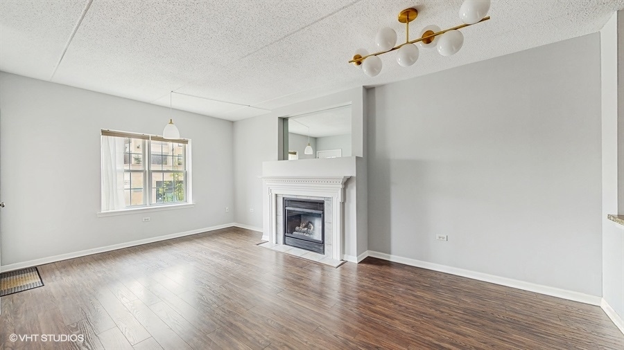 210 North Addison Avenue, Unit 202 Elmhurst, IL 60126 - Photo 2 of 21 wooden floor fireplace and windows in an empty room