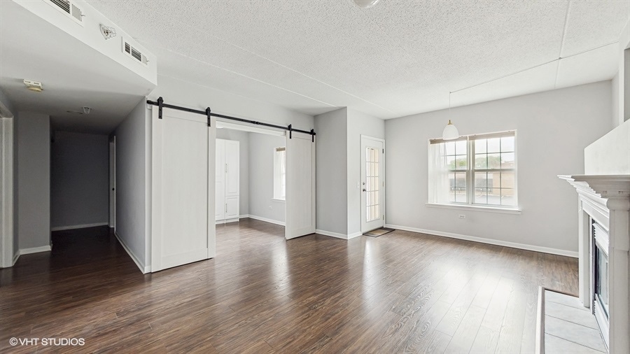 210 North Addison Avenue, Unit 202 Elmhurst, IL 60126 - Photo 3 of 21 an empty room with wooden floor and windows