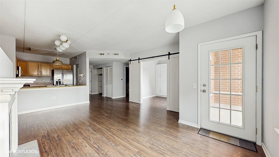 210 North Addison Avenue, Unit 202 Elmhurst, IL 60126 - Photo 4 of 21 a view of an empty room with wooden floor and a window