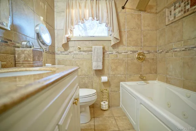a bathroom with a granite countertop sink mirror vanity and toilet