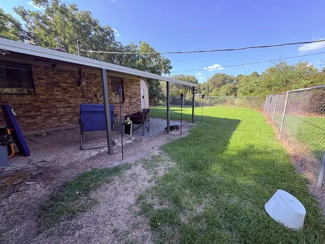 a view of a chair and table in backyard of the house