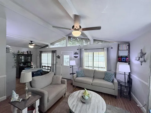 a living room with furniture a chandelier and a large window