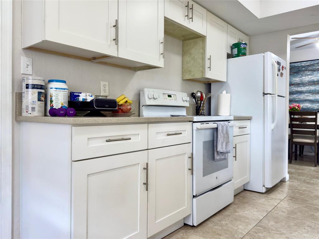 4510 Northwest 46th Street Tamarac, FL 33319 - Photo 11 of 34 a kitchen with white cabinets and white appliances