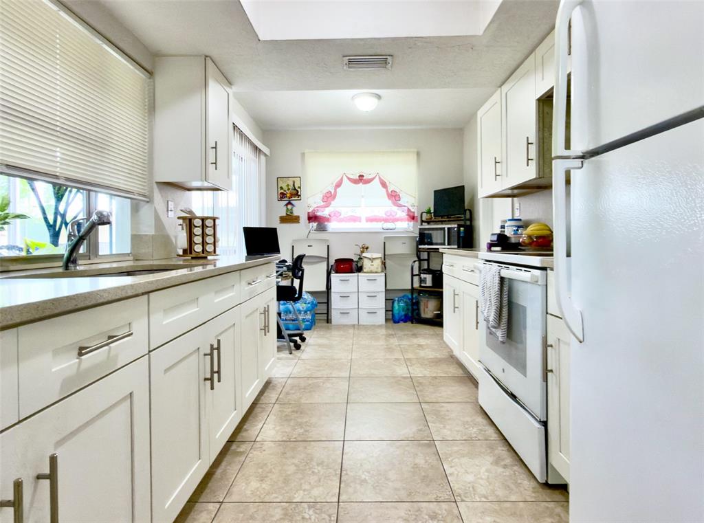 4510 Northwest 46th Street Tamarac, FL 33319 - Photo 12 of 34 a kitchen with stainless steel appliances granite countertop a stove and cabinets