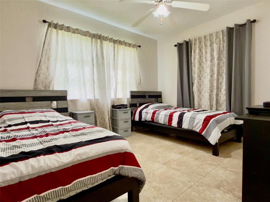 4510 Northwest 46th Street Tamarac, FL 33319 - Photo 20 of 34 a bedroom with a bed and a window