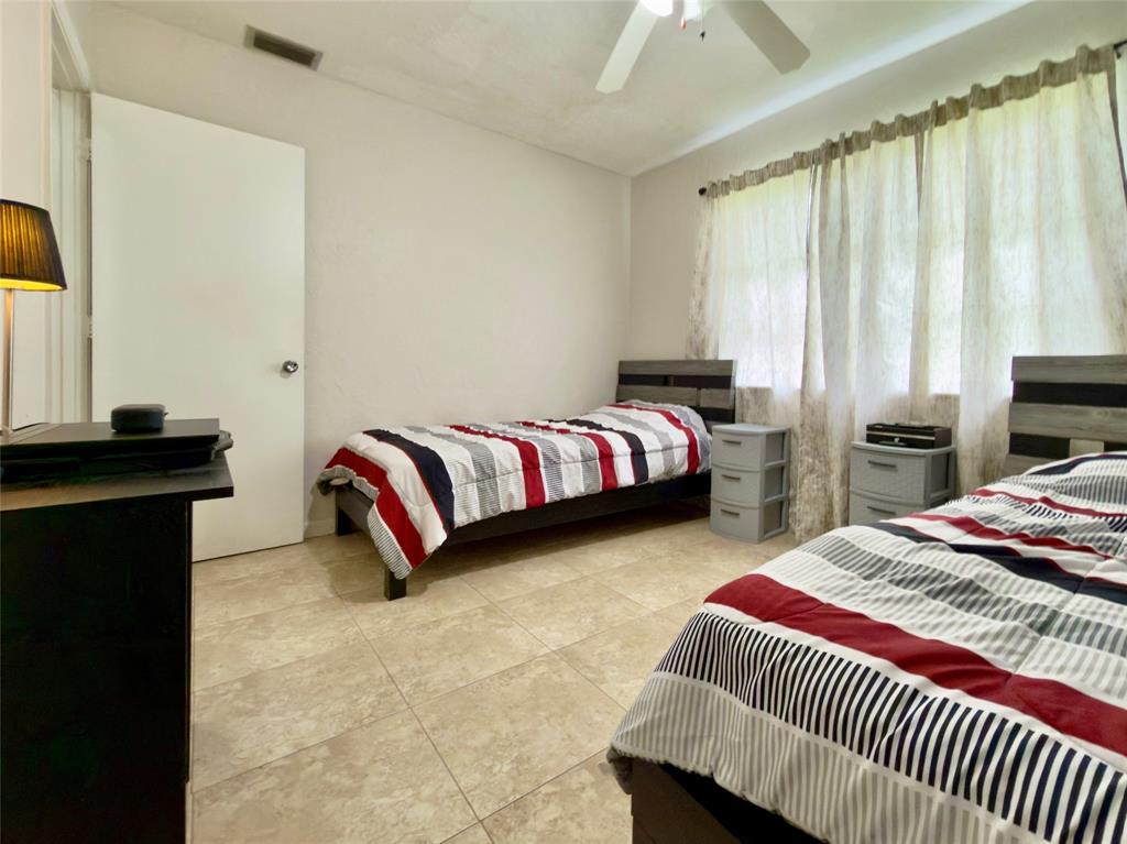 4510 Northwest 46th Street Tamarac, FL 33319 - Photo 21 of 34 a bedroom with bed and a chandelier