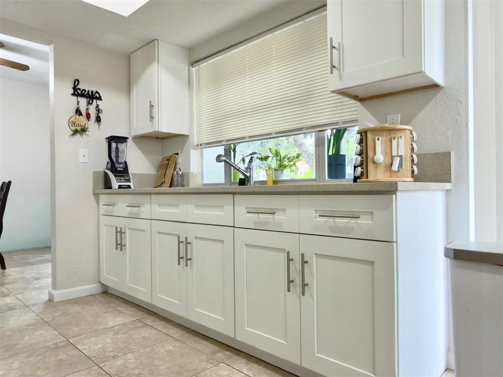 4510 Northwest 46th Street Tamarac, FL 33319 - Photo 9 of 34 a kitchen with white cabinets and window