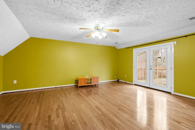 a view of a big room with wooden floor and windows