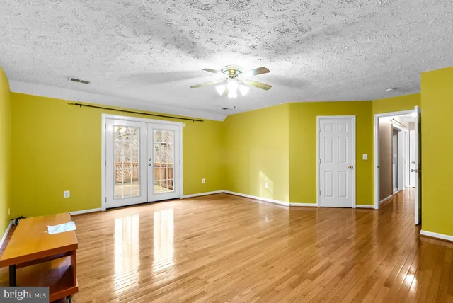 a view of a room with a wooden floor and a ceiling fan