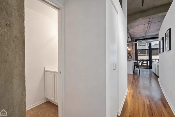 a view of a hallway with wooden floor and dining room