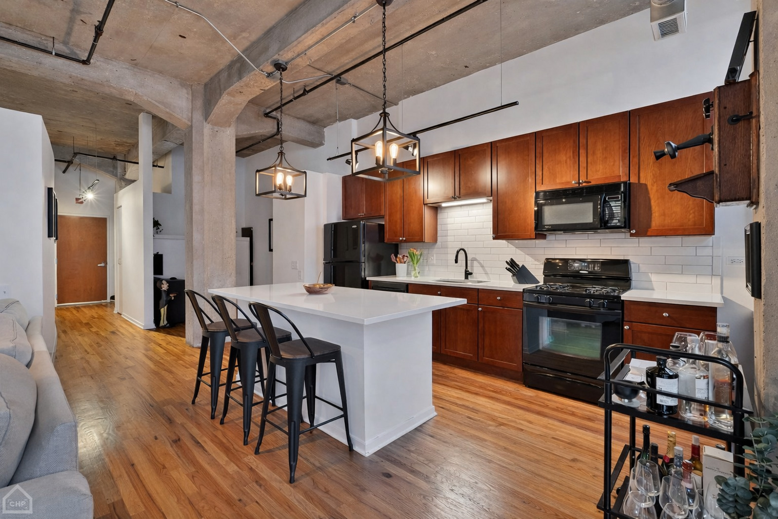 210 South Desplaines Street, Unit 404 Chicago, IL 60661 - Photo 4 of 22 a kitchen with stainless steel appliances granite countertop wooden floors stove and cabinets