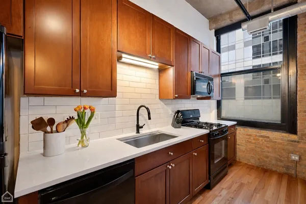 a kitchen with stainless steel appliances a sink a stove and wooden cabinets