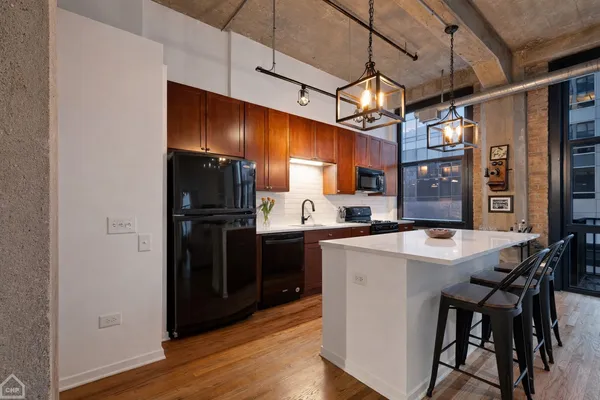 a kitchen with a refrigerator a sink and dishwasher with wooden floor