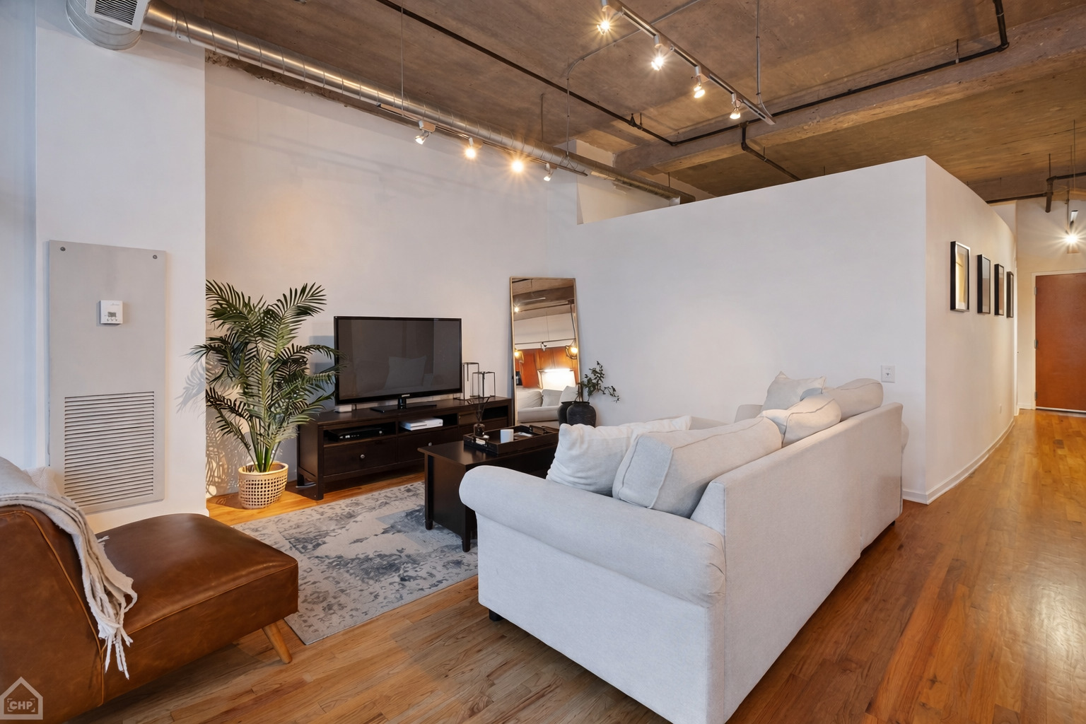 210 South Desplaines Street, Unit 404 Chicago, IL 60661 - Photo 10 of 22 a living room with furniture and a flat screen tv