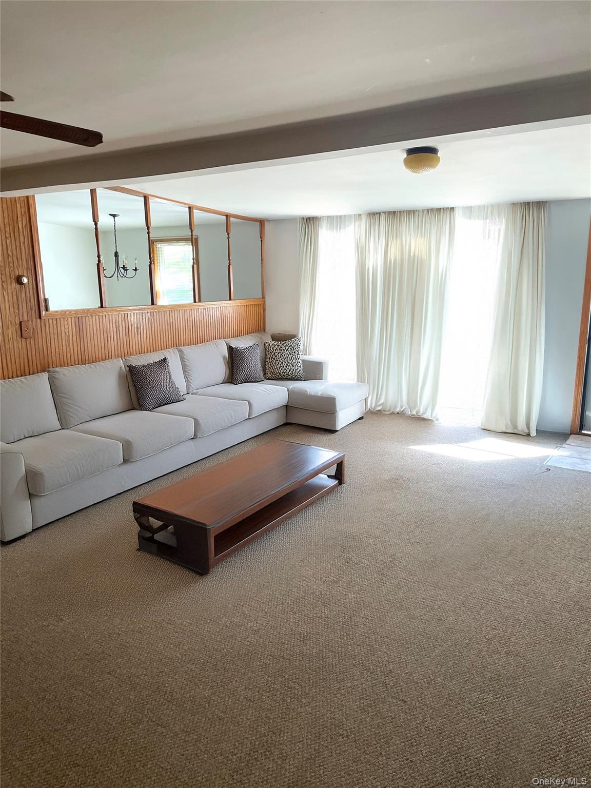 67 Bethlehem Road New Windsor, NY 12553 - Photo 12 of 19 AI generated:Living area featuring carpet, healthy amount of natural light, a chandelier, and wooden walls