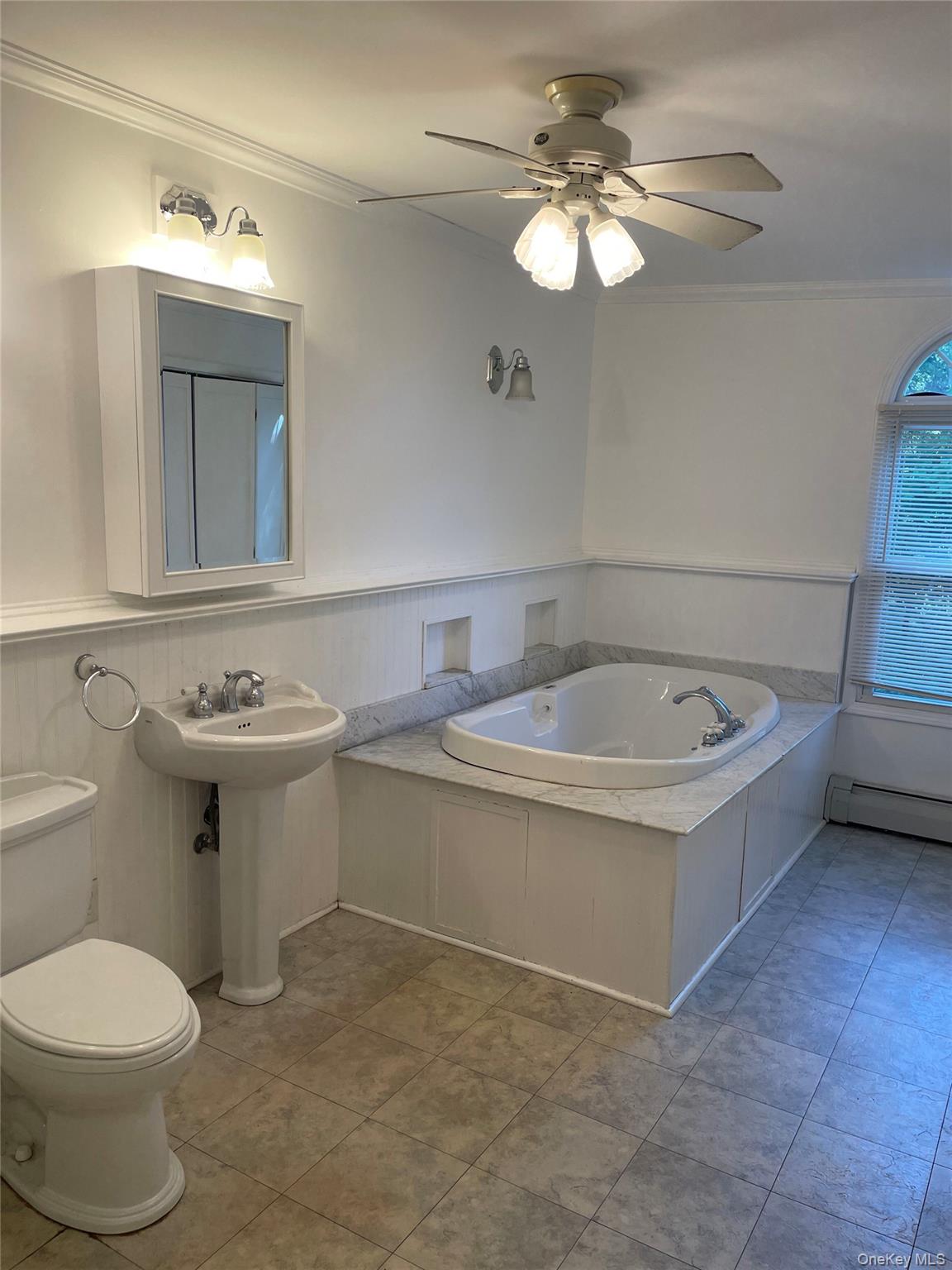 67 Bethlehem Road New Windsor, NY 12553 - Photo 15 of 19 Bathroom featuring crown molding, a baseboard radiator, a garden tub, a wainscoted wall, and ceiling fan
