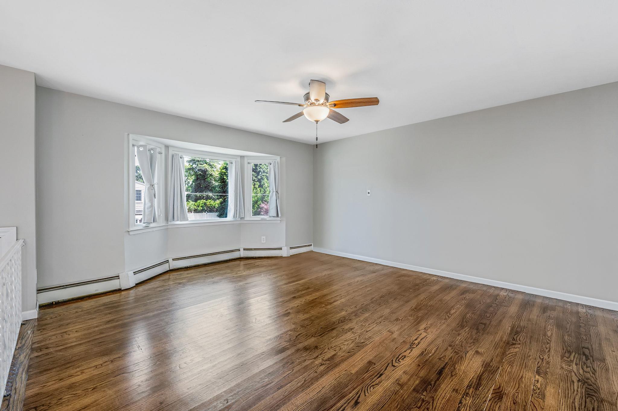 6 Holly Road Oakdale, NY 11769 - Photo 13 of 34 an empty room with wooden floor and windows