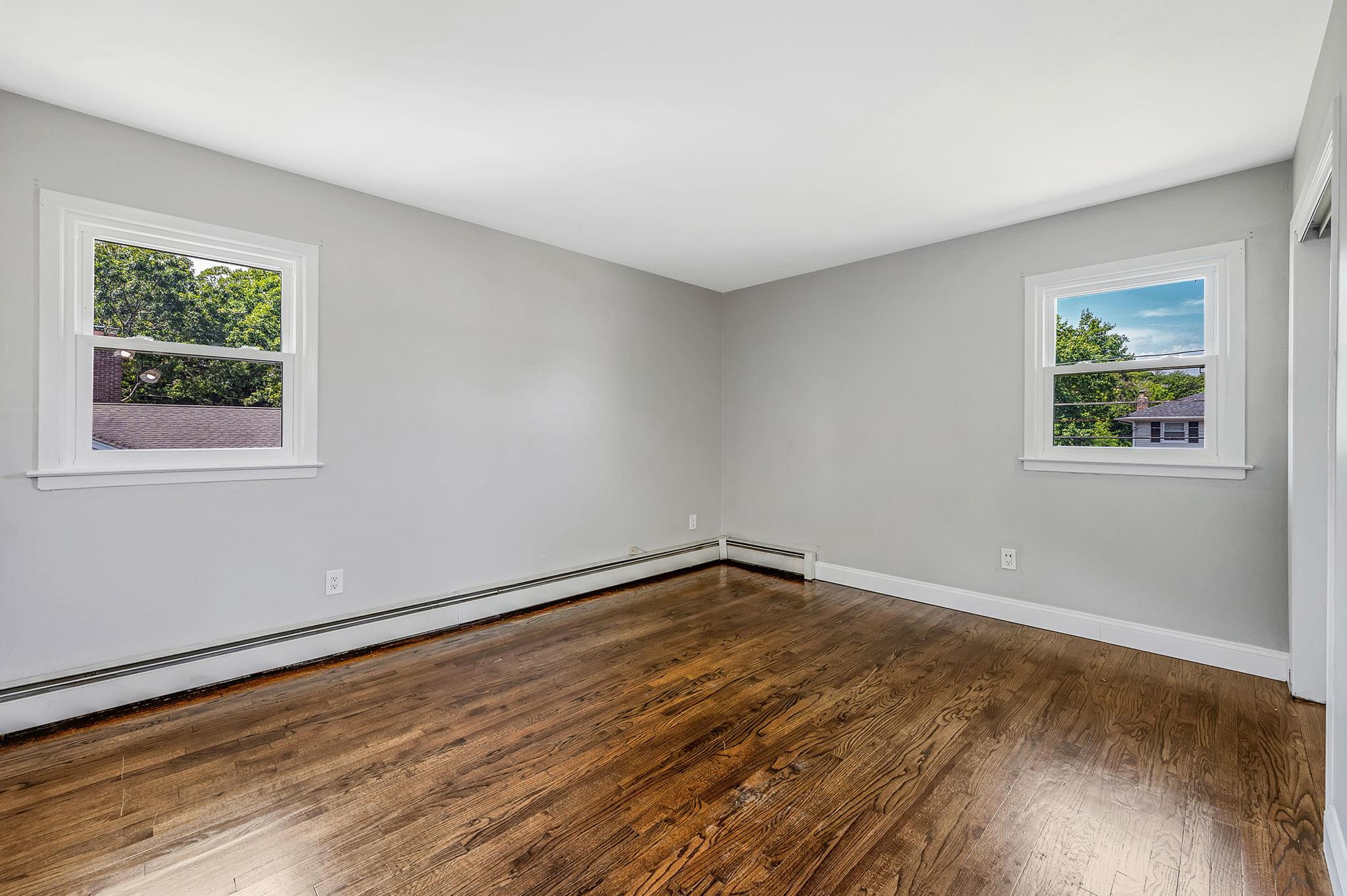 6 Holly Road Oakdale, NY 11769 - Photo 26 of 34 a view of an empty room with wooden floor and a window