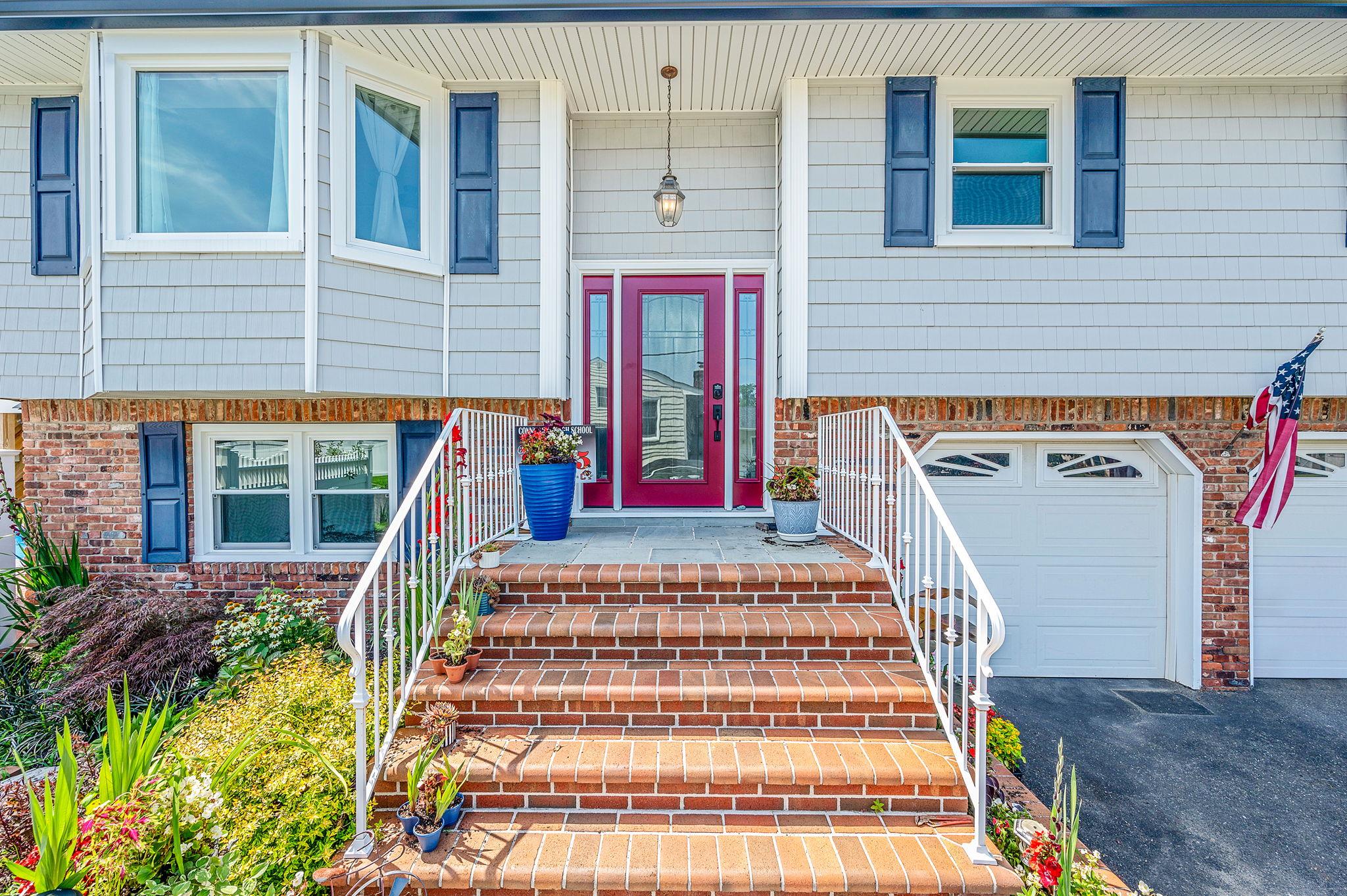 6 Holly Road Oakdale, NY 11769 - Photo 4 of 34 a front view of a house with large windows and a rug