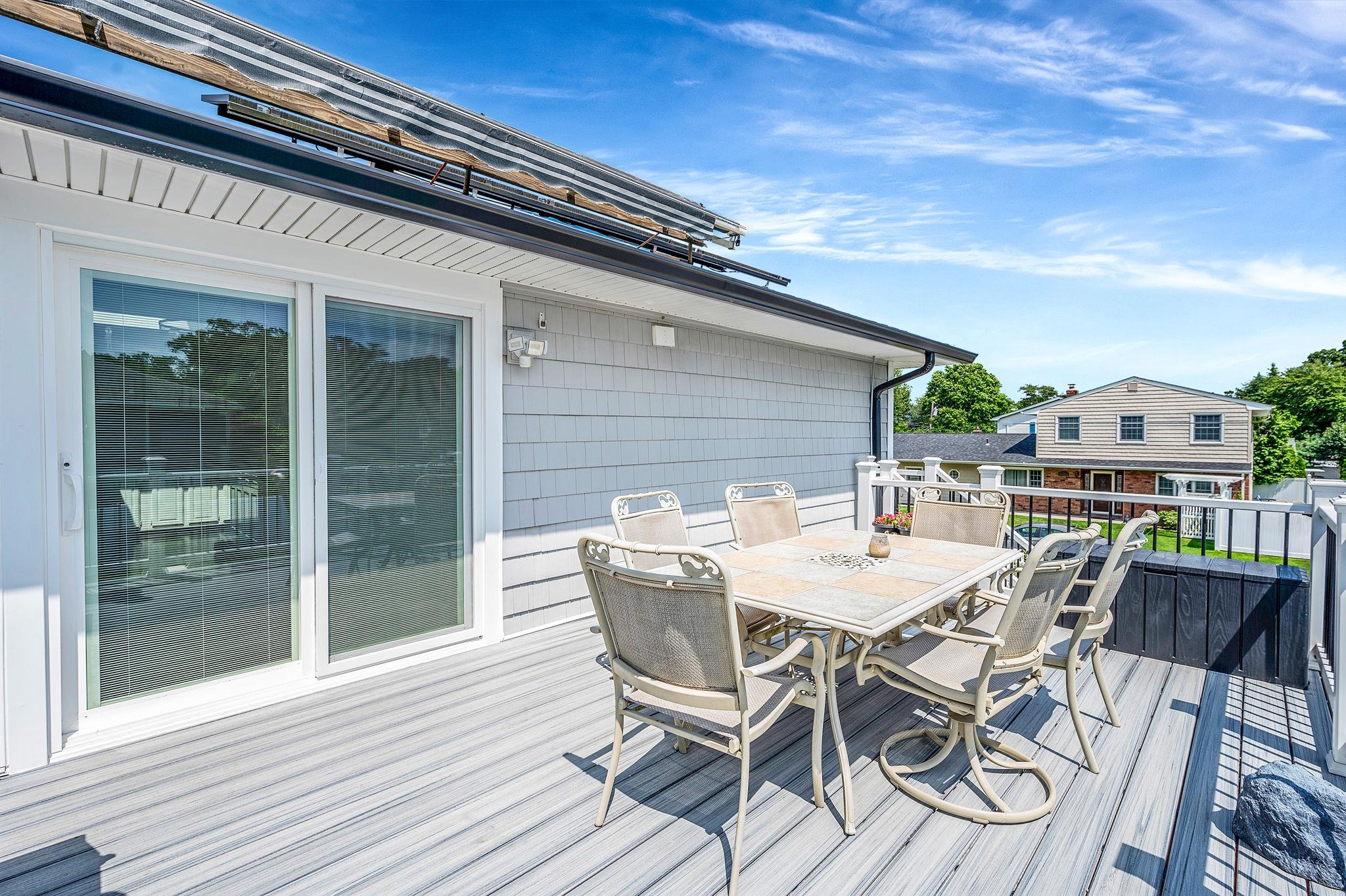 6 Holly Road Oakdale, NY 11769 - Photo 5 of 34 a view of a patio with a table and chairs and potted plants
